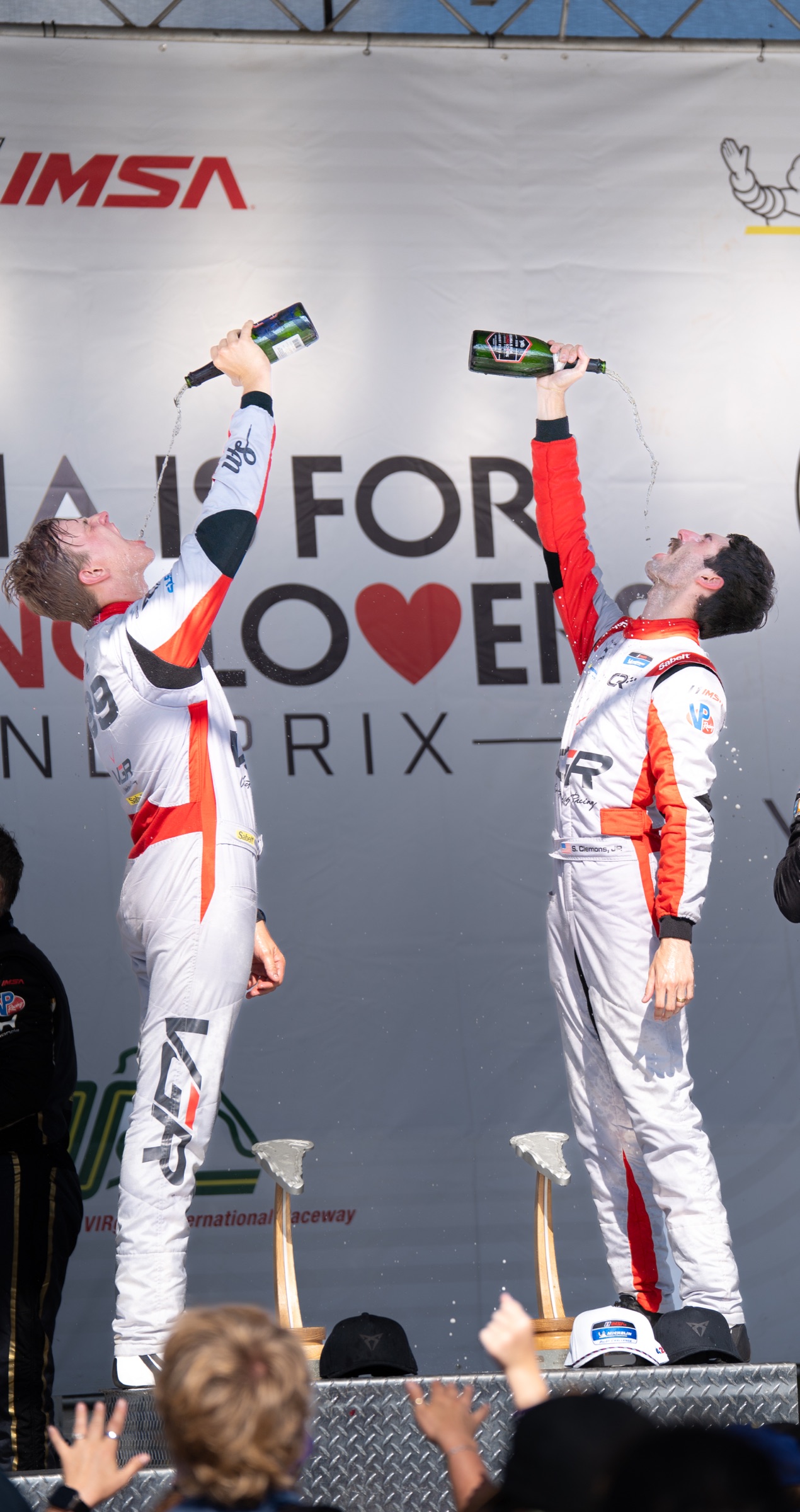 VGR No. 99 drivers celebrate with champagne on the VIR podium